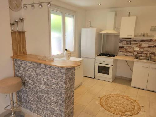 una cocina con una isla de piedra en el centro en Superbe appartement, en Saint-Hilaire-du-Rosier