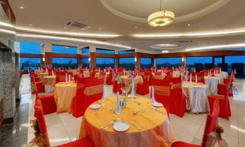 a banquet hall with red tables and chairs in a room at Ramada Plaza by Wyndham JHV Varanasi in Varanasi