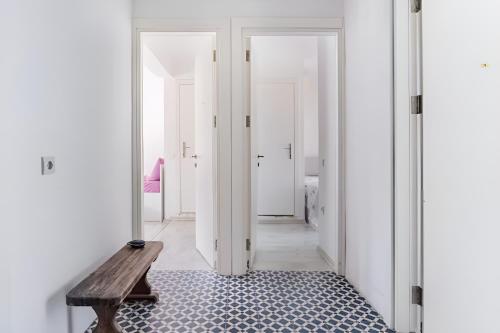 a hallway with a wooden bench and white walls at Seafront Rooms Bitez in Bodrum City