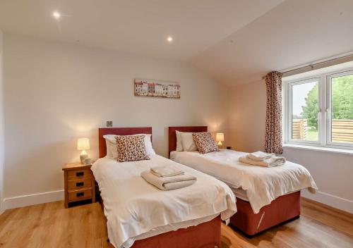 a bedroom with two beds and a window at Roosters Rest in Beccles