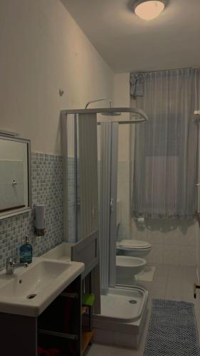 La salle de bains est pourvue de 2 lavabos, de toilettes et d'un miroir. dans l'établissement Claudia House, à Crotone