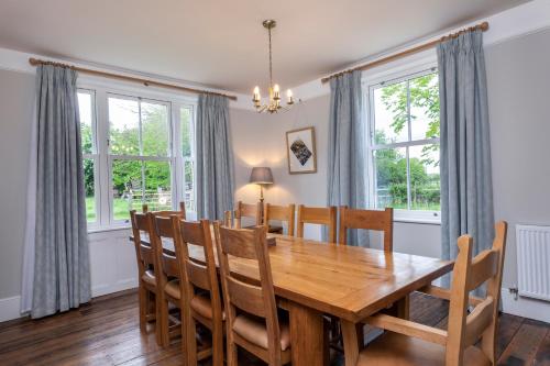 a dining room with a wooden table and chairs at The Old Farmhouse at Roughs Farm Retreats in Huntingdon