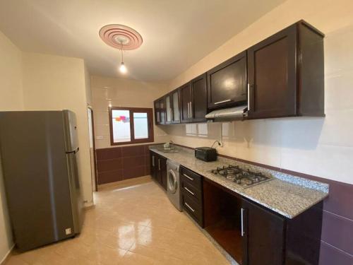 a kitchen with a stainless steel refrigerator and cabinets at Appartement à louer Al Hoceima - Mirador in Al Hoceïma