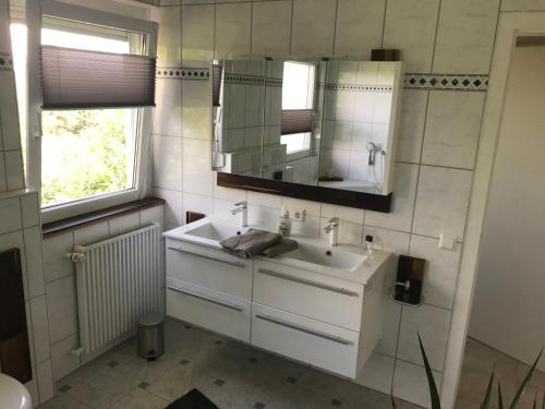 y baño con lavabo blanco y espejo. en Ferienwohnung Im Grünen, en Schramberg