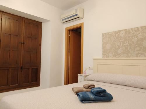 a bedroom with a bed with a blue towel on it at Casa Libélula Blanca Córdoba in Córdoba