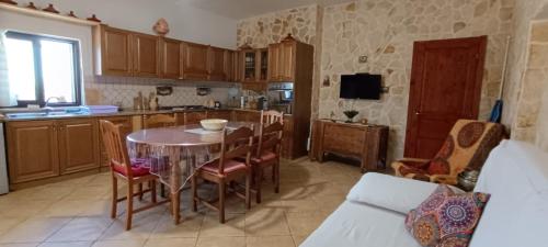 a kitchen with a table and chairs in a kitchen at Trulli Vāyu in Villa Castelli