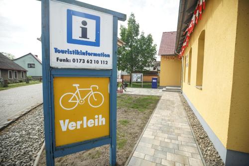 a sign with a bike on it next to a building at Apartment am Stettiner Haff in Mönkebude