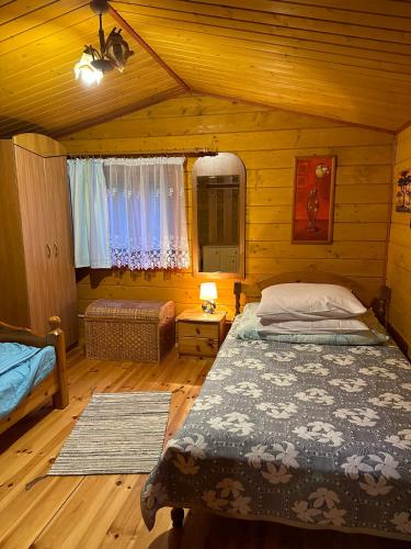 a bedroom with a bed in a log cabin at Eko-Wakacje in Polańczyk