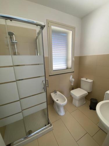 uma casa de banho com um chuveiro, um WC e um lavatório. em Casa Marsilla em Marzamemi