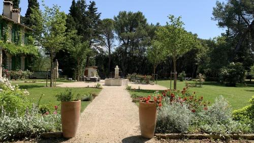 a garden with flowers and a fountain in a park at Domaine de Rhodes B&B in Avignon