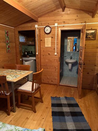 a dining room with a table and a sink in a cabin at Eko-Wakacje in Polańczyk