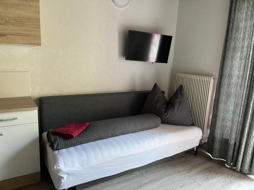 a couch in a room with a television on the wall at Pension Steiner, 6143 Matrei am Brenner!!Check-in between 15 - 21 o'clock!! No breakfast in Mühlbachl