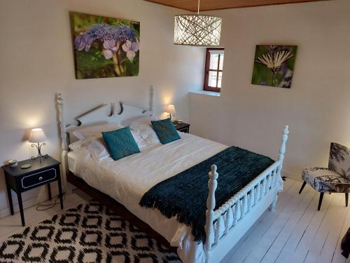 1 dormitorio con cama blanca y almohadas azules en Meric Gites, en Dolmayrac