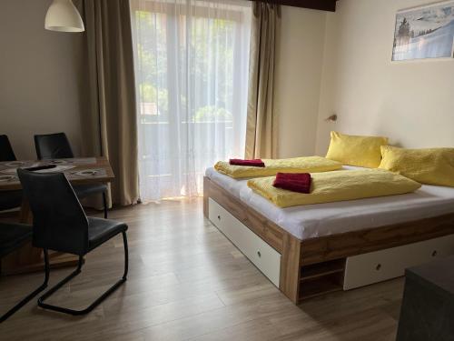 a bedroom with a bed with a chair and a window at Pension Steiner, 6143 Matrei am Brenner!!Check-in between 15 - 21 o'clock!! No breakfast in Mühlbachl