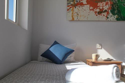 a bedroom with a bed with a blue pillow on it at CityScape Gzira Holiday Apartments and Penthouse in Il-Gżira