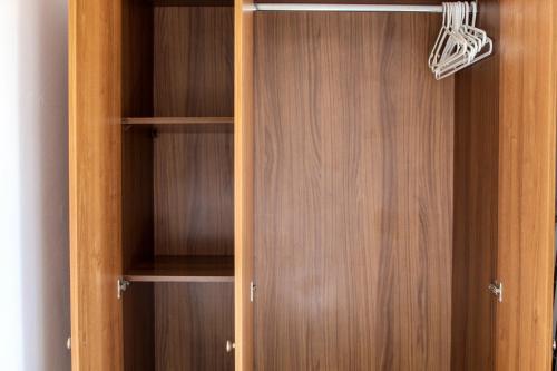 a wooden closet with wooden doors and shelves at CityScape Gzira Holiday Apartments and Penthouse in Il-Gżira