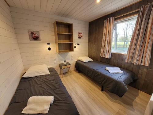 a room with two beds in a tiny house at Camping la Venise Verte in Coulon