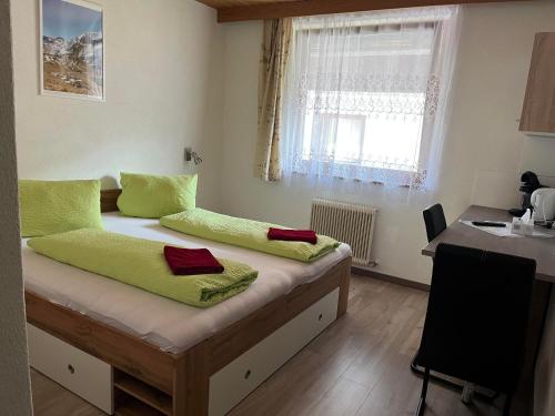 een slaapkamer met een bed met groene en rode handdoeken erop bij Pension Steiner, Matrei am Brenner 18b, 6143 Matrei am Brenner in Mühlbachl