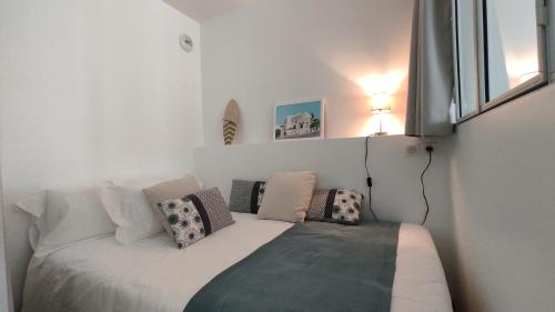 a small room with a bed with pillows on it at Mira Marvel - WIFI - Climatisation - 100m plage in Biarritz