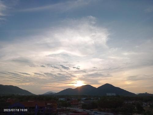 a sunset over a city with mountains in the background at Homestay Triple Q Manjung in Seri Manjung