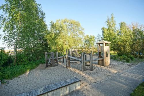 a playground in a park with a wooden fence at Apartment am Stettiner Haff in Mönkebude