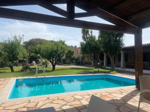 una piscina en un patio con una casa en La casa di Simona, en Telti