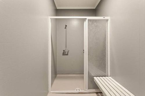 uma cabina de duche na casa de banho com um banco em Svanøy Gjestehus em Floro