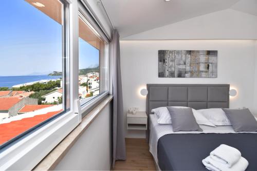 1 dormitorio con cama y ventana grande en Luxury Apartments Luna, en Tučepi