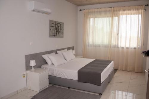 - une chambre blanche avec un lit et une fenêtre dans l'établissement Villa Spilies, à Peyia