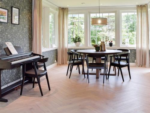 a dining room with a piano and a table and chairs at Holiday home GAMLE FREDRIKSTAD in Trolldalen