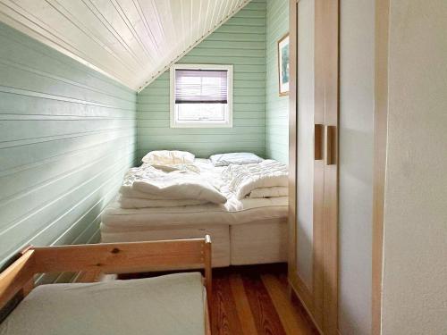ein kleines Bett in einem grünen Zimmer mit Fenster in der Unterkunft Holiday home Skjærhalden in Skjærhollen