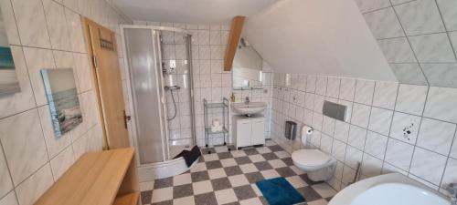 a bathroom with a sink and a shower and a toilet at Ferienwohnung "Fernblick" Wolzhausen in Breidenbach