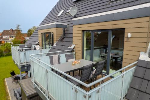 a balcony of a house with a table and chairs at Ragnar Maisonette in Büsum