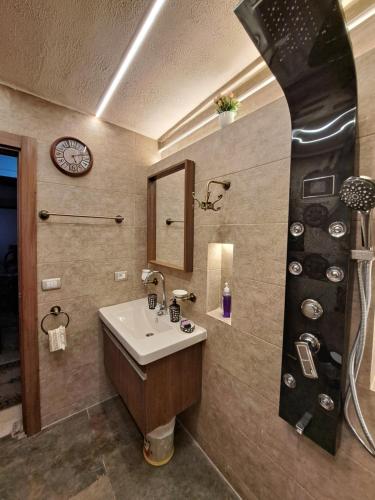 a bathroom with a sink and a clock on the wall at Panorama apartment with a charming view of Cairo International Airport All the apt for you with free airport pick up or drop off limousine شقة بانوراما بإطلالة ساحرة على مطار القاهرة الدولي in Cairo