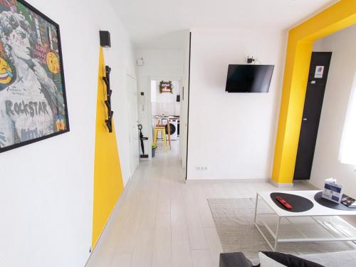 una sala de estar con paredes amarillas y blancas. en XOXO - Arco, en Ponferrada