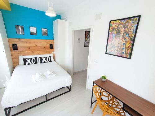 a bedroom with a white bed and a blue wall at XOXO - Arco in Ponferrada