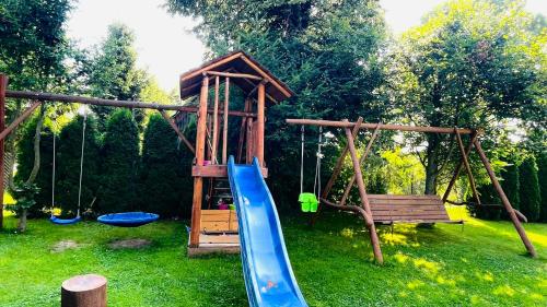 a playground with a blue slide and a bench at Dom Gościnny Kama in Tylicz