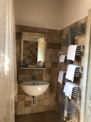 y baño con lavabo, espejo y toallas. en Il Capisterium en Norcia