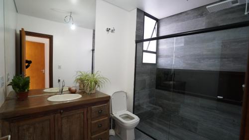 uma casa de banho com um lavatório, um WC e um chuveiro em Casa do Sol em Diamantina