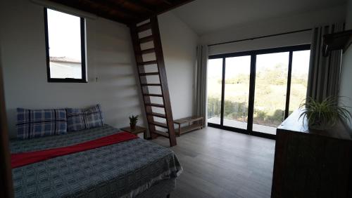 a bedroom with a bed and a ladder and a window at Casa do Sol in Diamantina