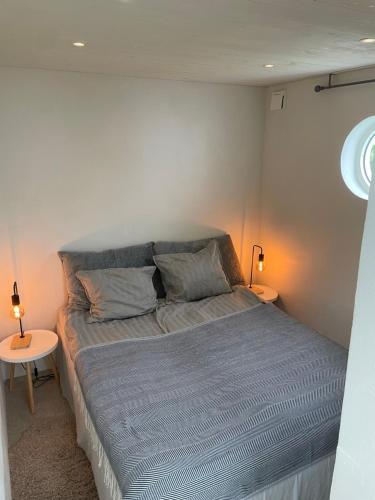 1 cama en una habitación pequeña con 2 mesas en Lilla kyrkhuset på Råå, en Helsingborg