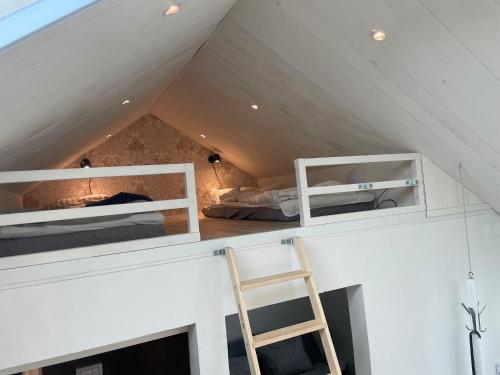 Zimmer mit 2 Etagenbetten und einer Leiter in der Unterkunft Lilla kyrkhuset på Råå in Helsingborg