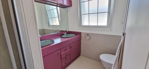 ein rosafarbenes Bad mit einem WC und einem Waschbecken in der Unterkunft Villa du Logis in Landivisiau