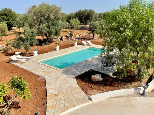 una imagen de una piscina en un patio en Trullo Bubamare en San Michele Salentino