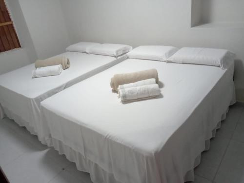 two beds in a room with towels on them at Casa Bela Vista in Piranhas