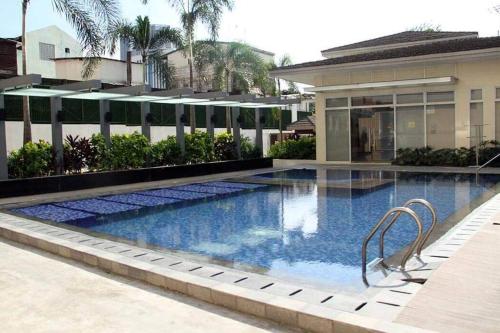 a swimming pool in front of a building at 2-BR COZY condo 200mbpsFiberWiFi/Netflix/pool/WFH in Manila