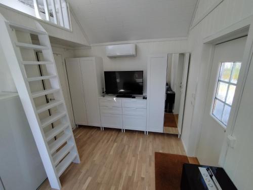 a living room with a flat screen tv and a living room at Guesthouse with terrace in Arendal
