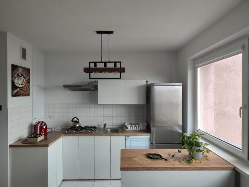 a kitchen with white cabinets and a stainless steel refrigerator at Chill Studio in Łódź