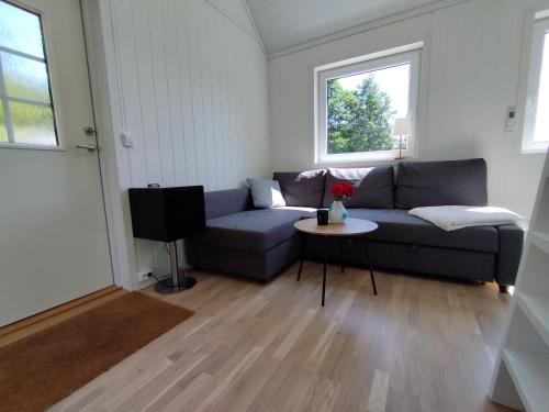 a living room with a couch and a table at Guesthouse with terrace in Arendal