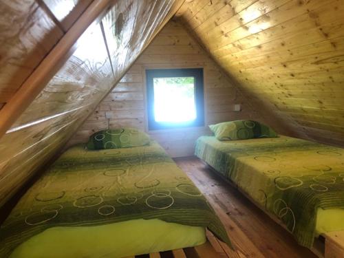a bedroom with two beds in a log cabin at Koliba Joca in Lepterija